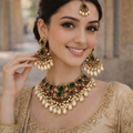 Woman wearing elaborate gold and green jewelry set outdoors

