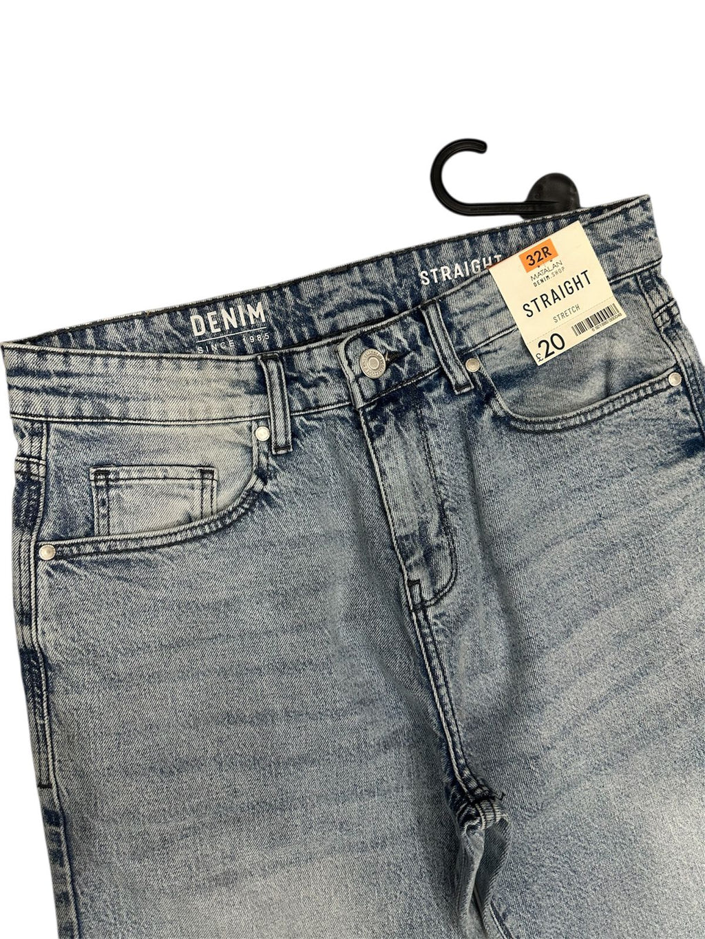 Pair of blue jeans with a tag on a white background


